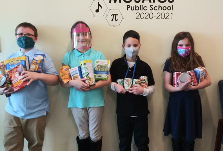 students holding food under MOSAICS Sign